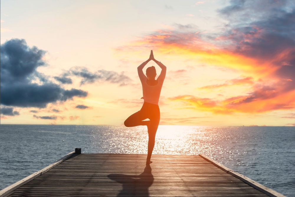 Woman practising yoga near the sea