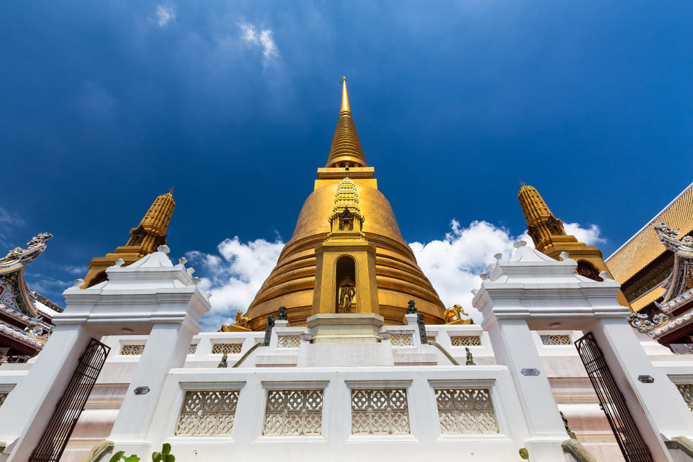 Golden pagoda and white walls at Wat Bowon Niwet