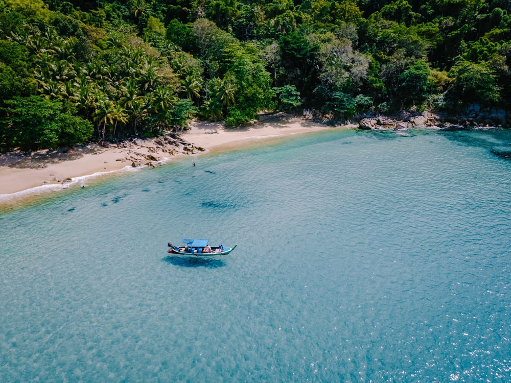 Boat floating on crystal clear sea water of Banana Beach, Phuket