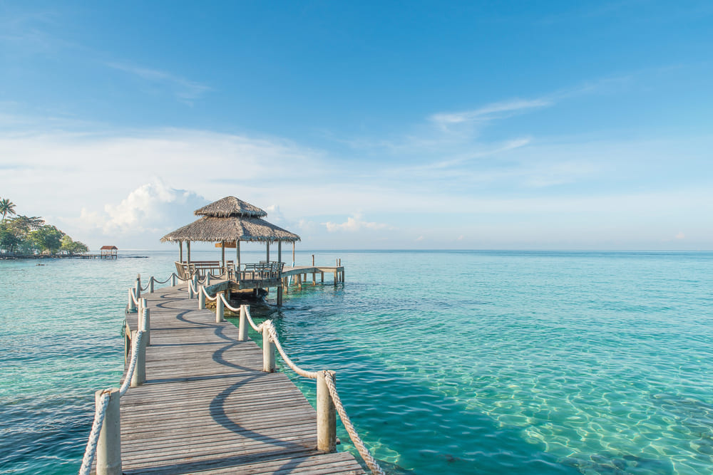 Tropical hut and wooden bridge in the sea at Koh Kood, Trat