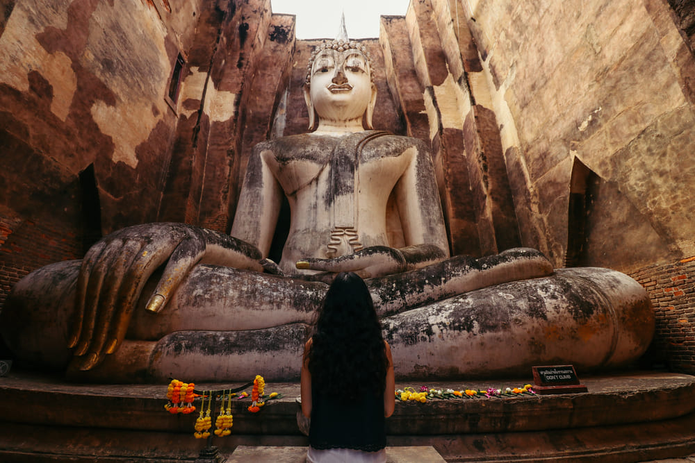 Woman looking up at the Buddha Statue at Wat Si Chum, Sukhothai