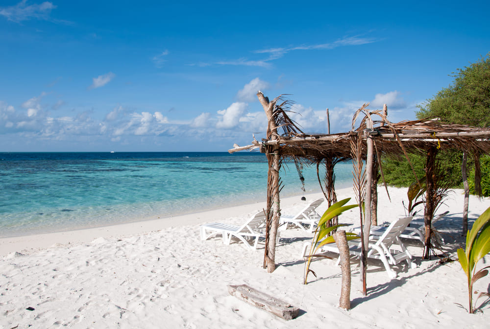 Sunbeds on the white beach in Thinadhoo, Maldives Island