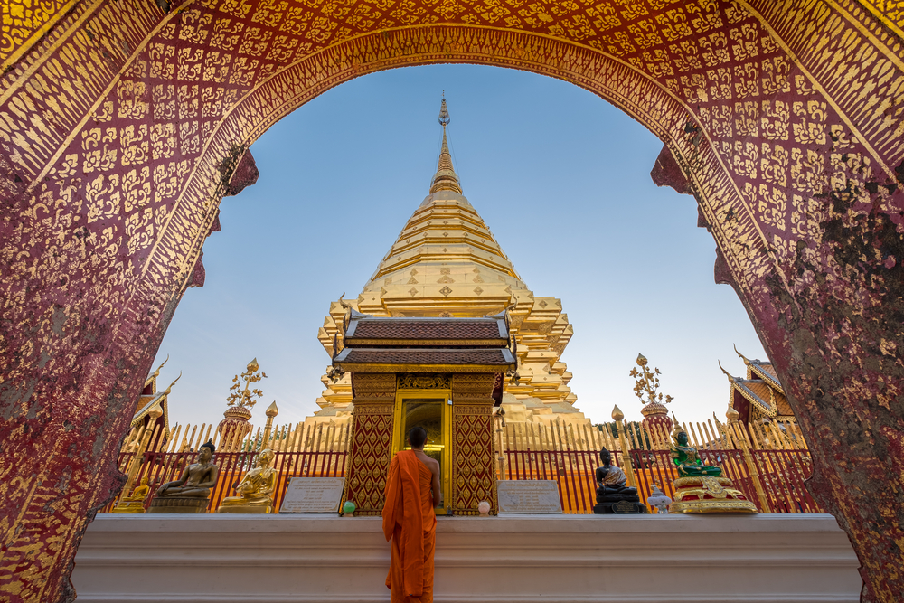 Monk looking at golden pagoda at Wat Phra That Doi Suthep