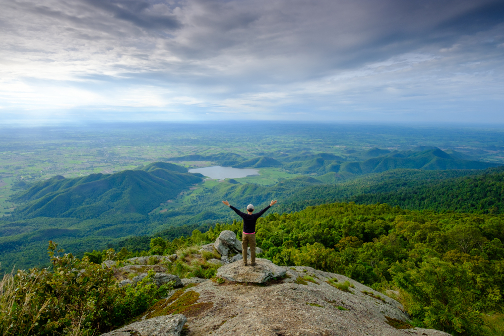 Man standing on cliff at Khao Luang in Ramkhamhaeng National Park