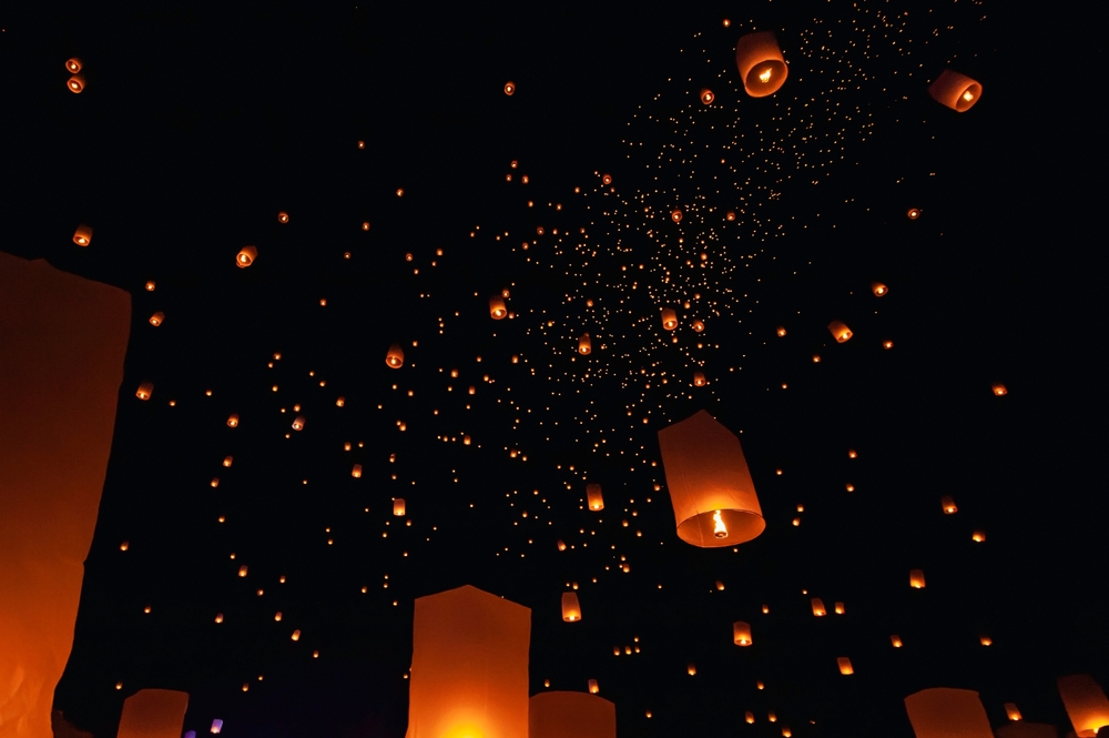 Many sky lanterns glowing and floating in the sky during Yee Peng Festival