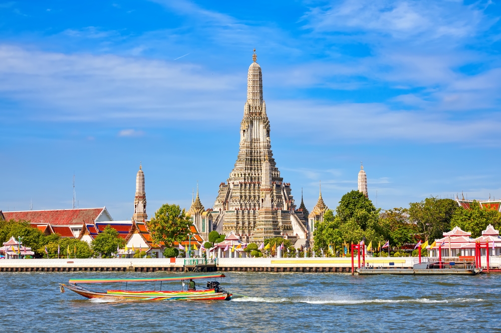 Prang at Wat Arun in Bangkok, next to the river under a clear sky