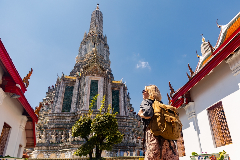 Female traveler standing in front of the Prang at Wat Arun in Bangkok