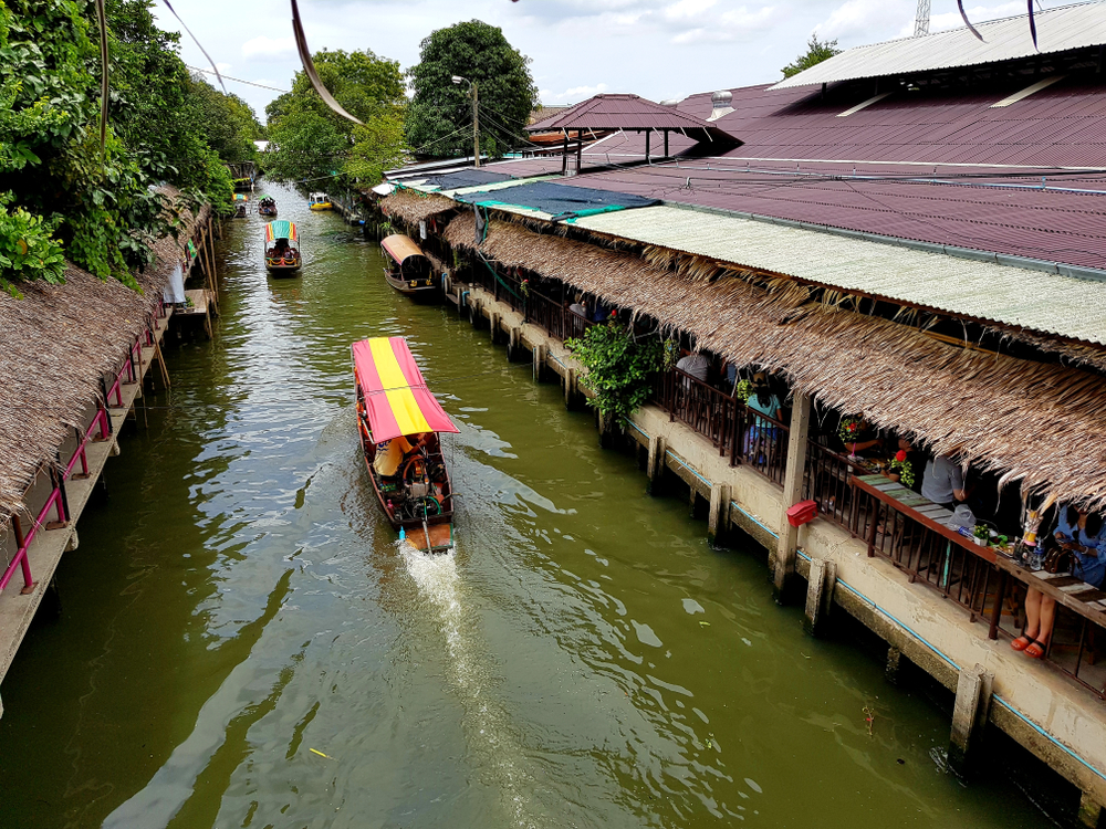 Longtail boat going through the canal at Khlong Lat Mayom Floating Market