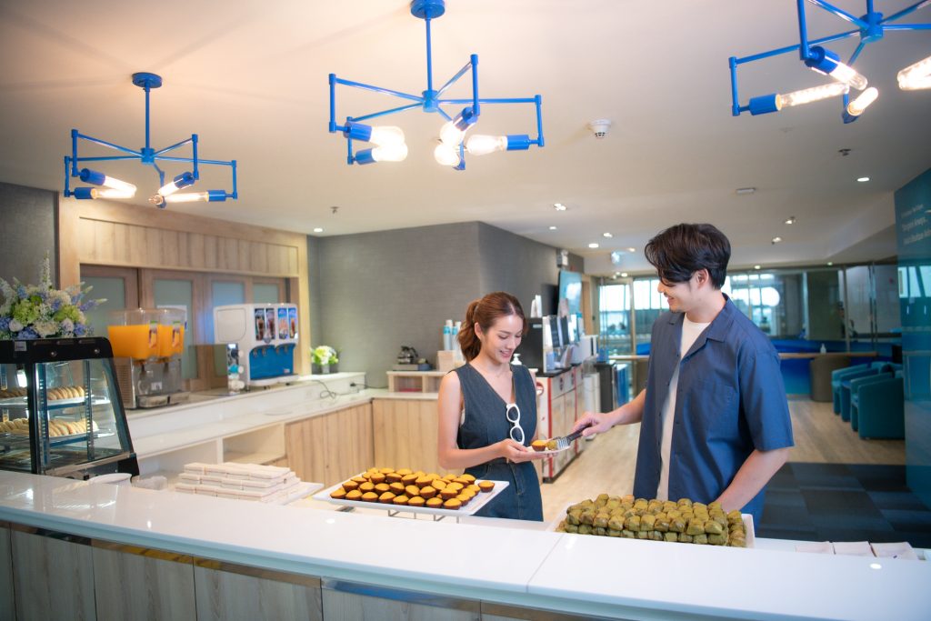 A man serving dessert to a woman at the Bangkok Airways Boutique Lounge.