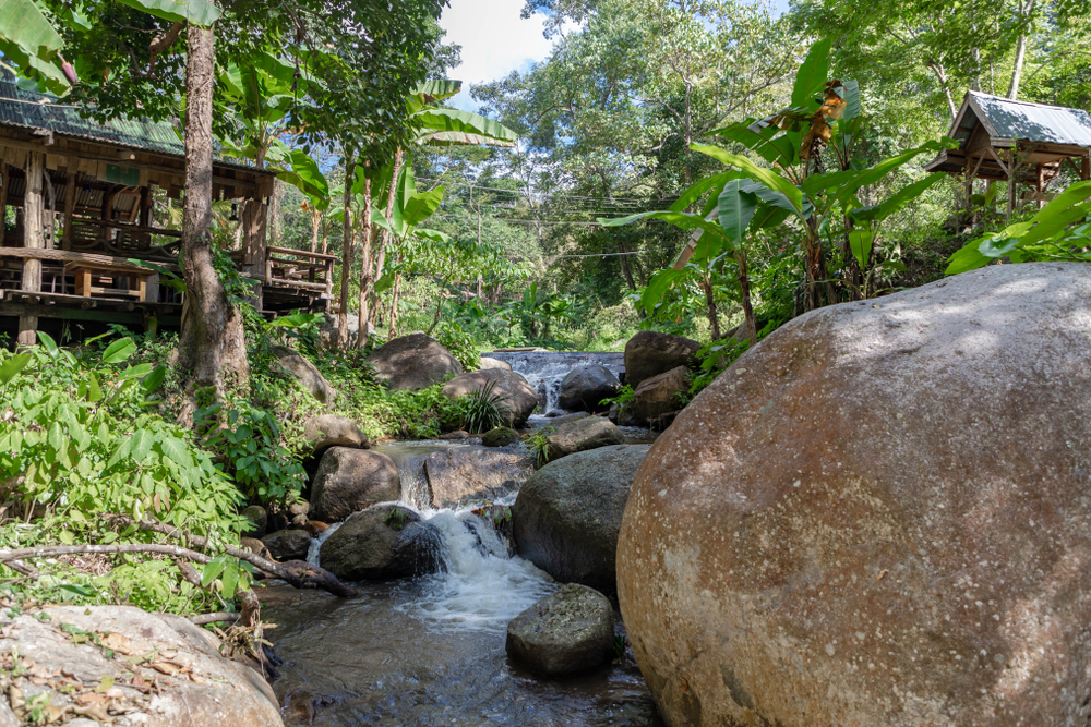 A small lake flowing through rocks in the jungle at Ban Pa Miang, Lampang, Thailand