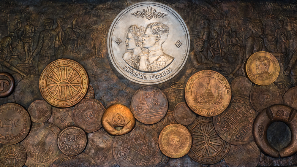 Thailand’s previous King and Queen on the ceremony coin and other Thai coins all around