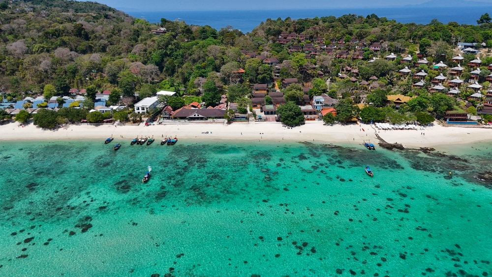 Crystal-clear waters and a white sand beach of Long Beach, surrounded by green islands in Koh Phi Phi