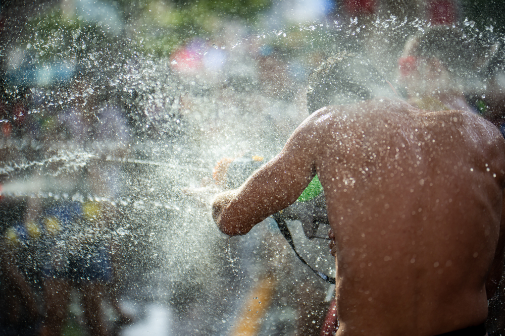 A man armed with a water gun in the middle of the water fight during Songkran