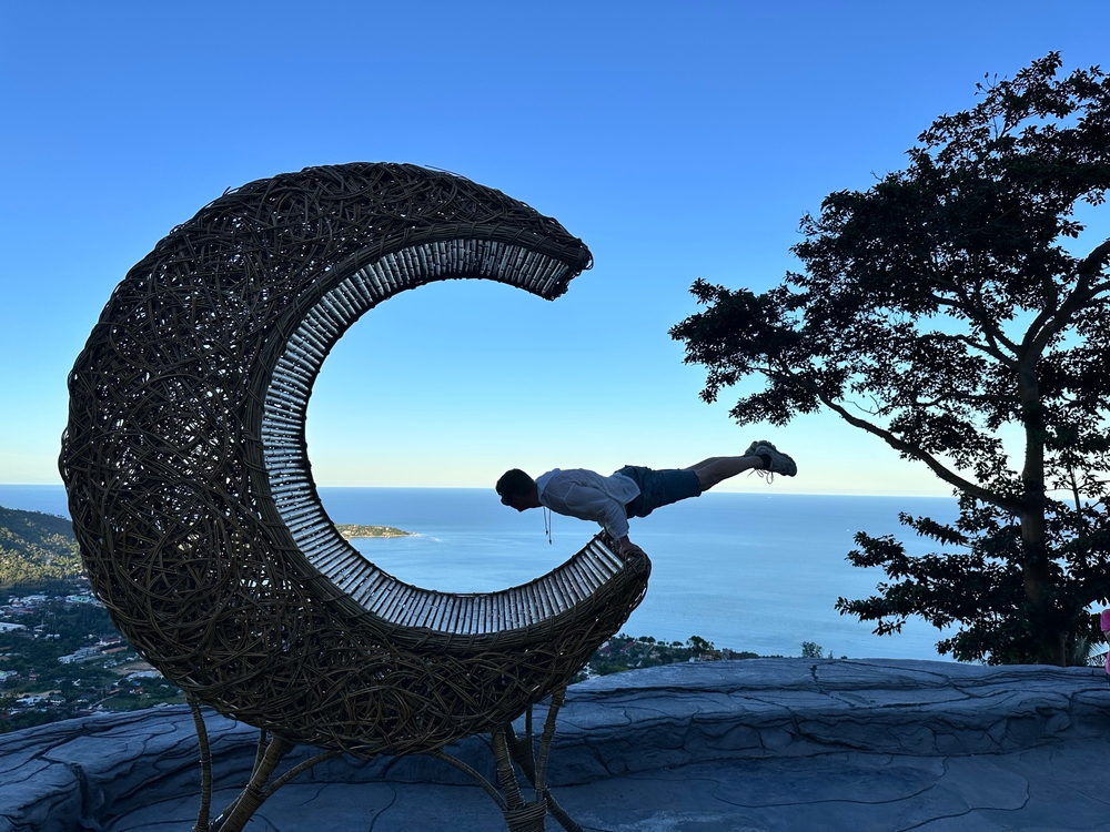A young man posing at the popular crescent moon seat, an Instagrammable spot at Overlap Stone 2.