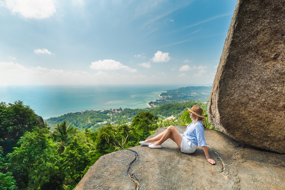A traveler relaxing and soaking in the turquoise waters of Lamai Beach from Overlap Stone 1.