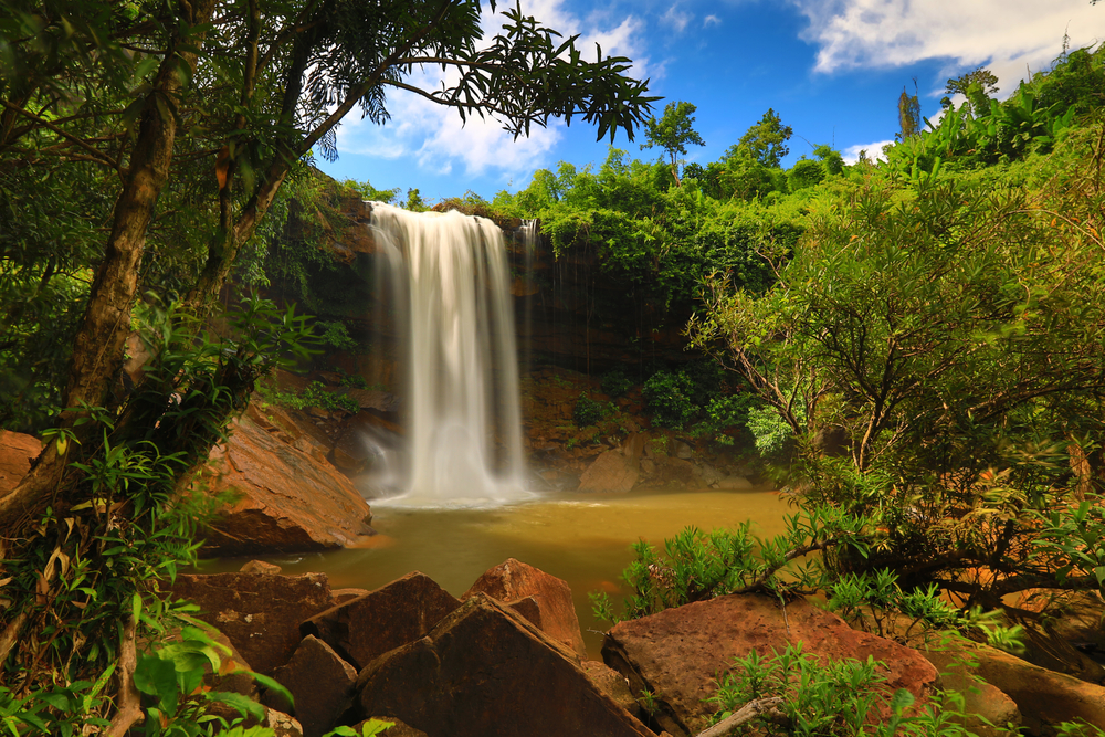 Saphan Hin Waterfall in Trat, a charming waterfall in Thailand cascading into a natural pool surrounded by large rocks.