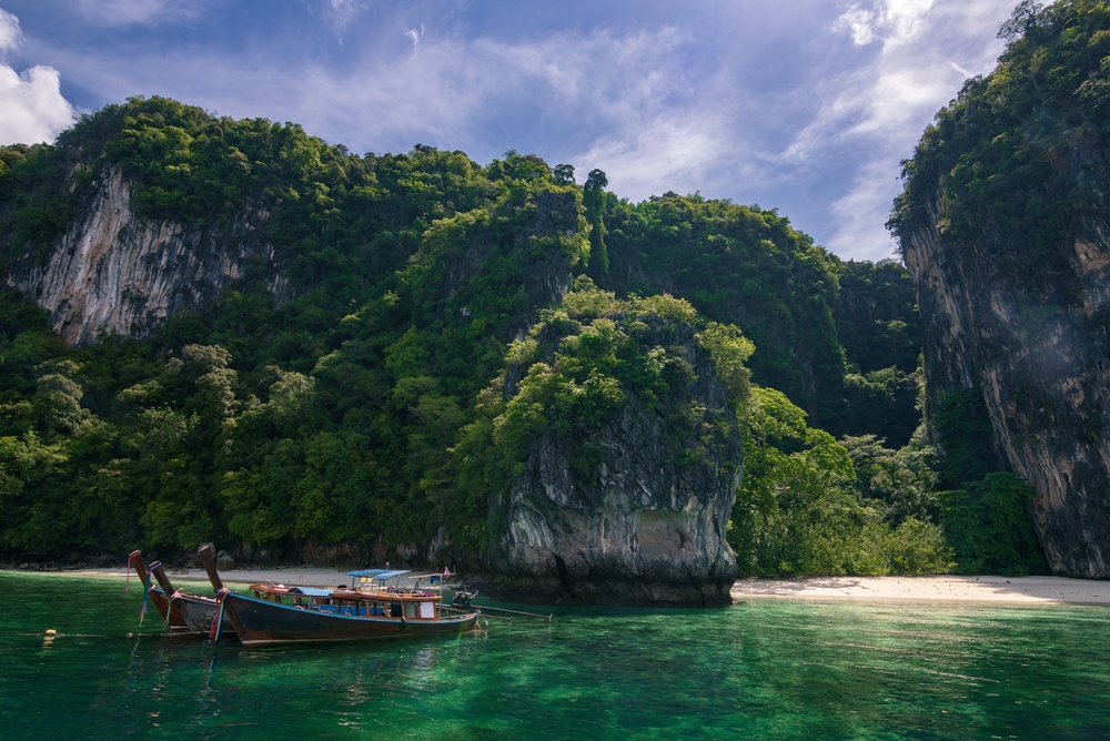 เรือหางยาวบริการนักท่องเที่ยวจอดเทียบท่าอยู่ริมชายหาดเกาะห้อง
