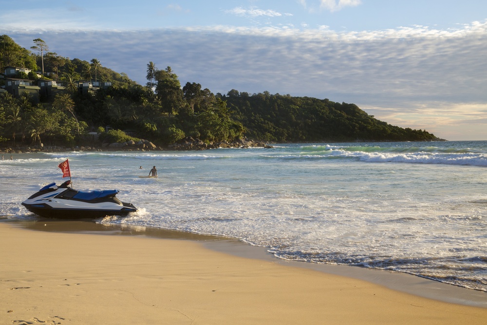 Surfing and beach activities at Kata Beach in Phuket during the rainy season in Southeast Asia.