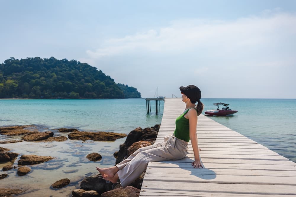 นักท่องเที่ยวนั่งรับลมชิล ๆ บนสะพานไม้ริมหาดบางเบ้า ที่เกาะกูด จุดหมายสโลว์ไลฟ์บนเกาะที่สวยที่สุดในไทย