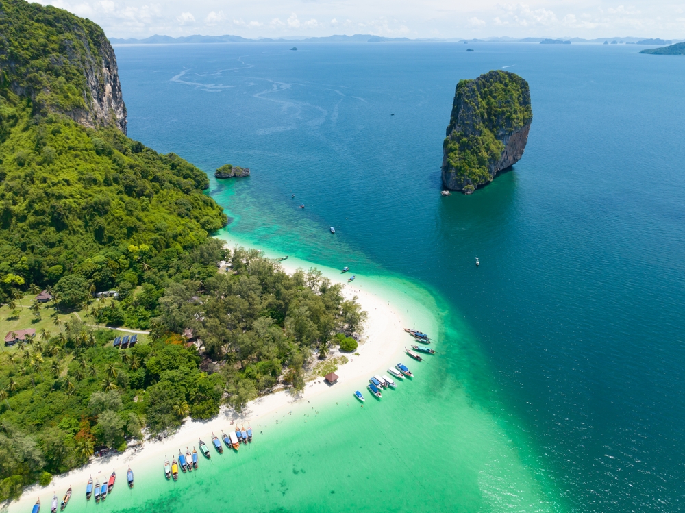 ภาพมุมสูงวิวธรรมชาติของเกาะปอดะ กระบี่ เห็นแนวหาดทรายขาว ทะเลสีเขียวมรกต และโขดหินปูนโดดเด่นกลางทะเล