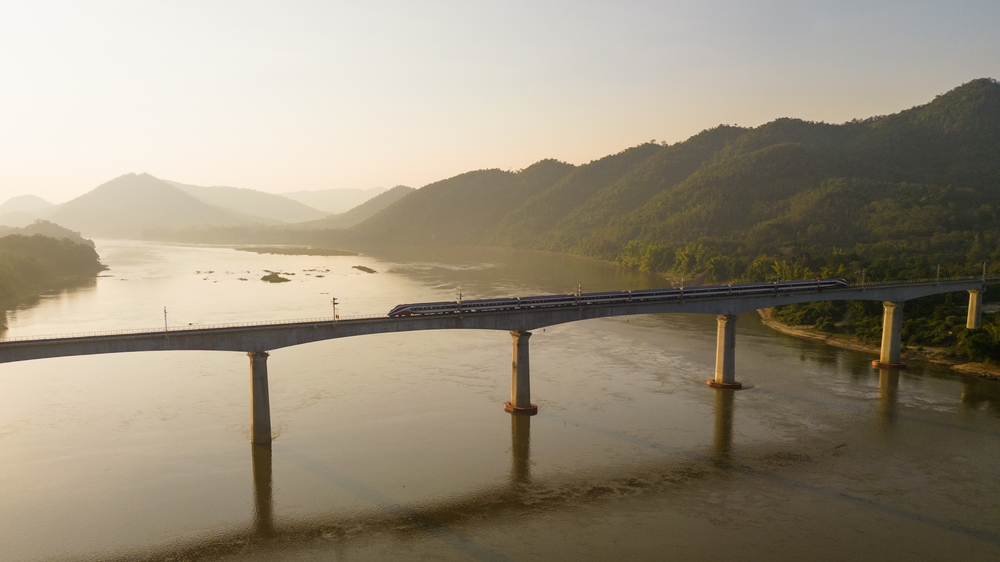 A Laos-China Railway train crossing a scenic bridge, a fast and convenient way to get from Luang Prabang to Vang Vieng.