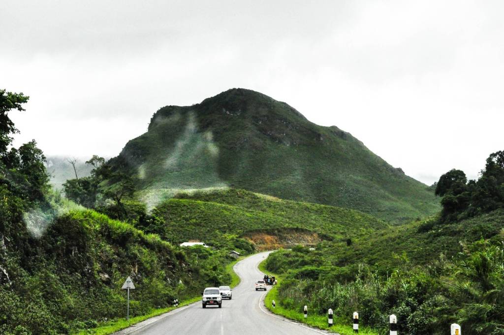 A minivan traveling on a scenic mountain road, a popular and scenic route from Luang Prabang to Vang Vieng.