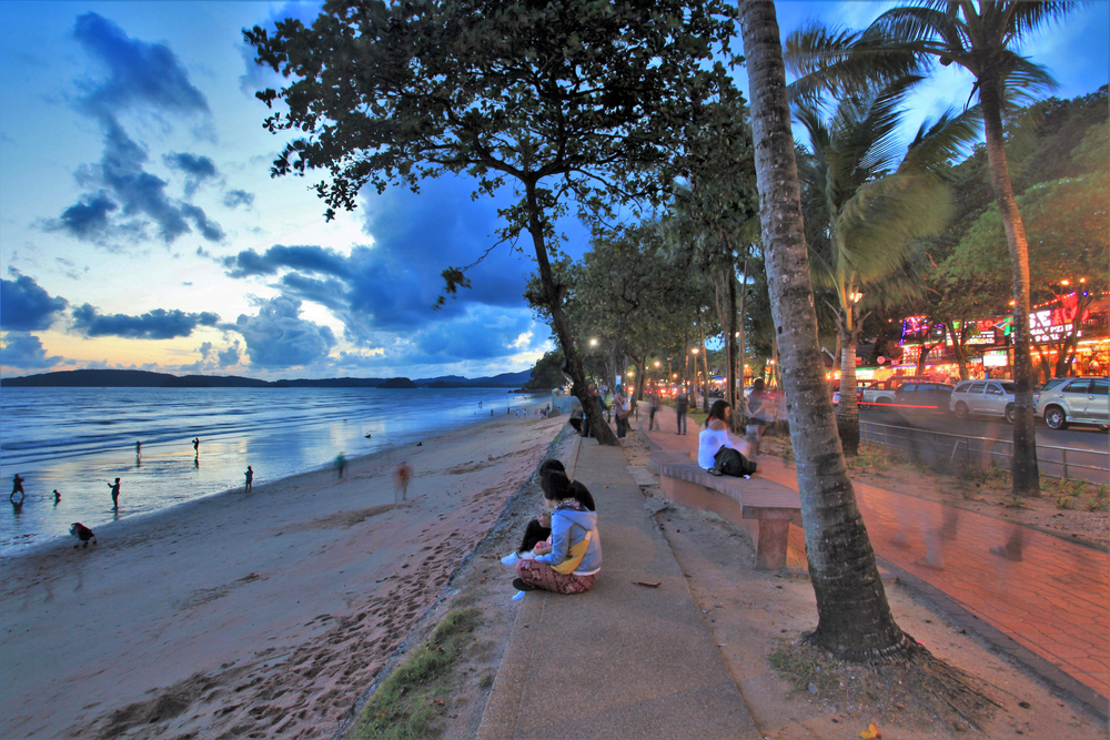 Evening atmosphere and tourists relaxing near the vibrant Ao Nang Beach, Krabi.