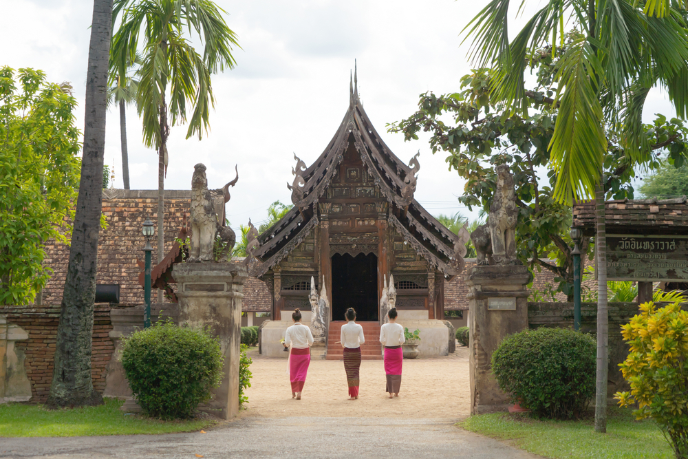 นักท่องเที่ยวสวมชุดไทยล้านนาเดินเข้าชมวิหารโบราณที่วัดต้นเกว๋น วัดในเชียงใหม่ที่ให้บรรยากาศงดงาม