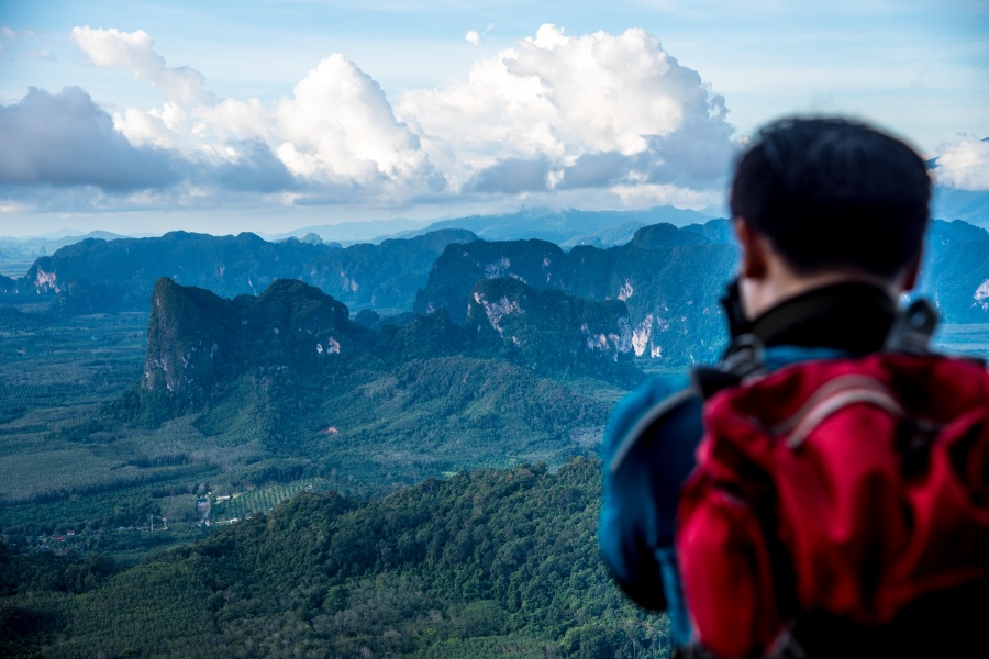 A hiker admiring panoramic mountain views from Khao Ngon Nak near Ao Nang Beach in Krabi, Thailand.