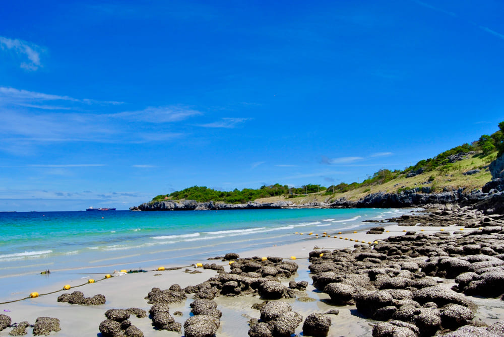 แนวโขดหินและชายหาดน้ำใสบนเกาะสีชัง ชลบุรี บรรยากาศเงียบสงบเหมาะกับการจัดทริปเที่ยวคนเดียว