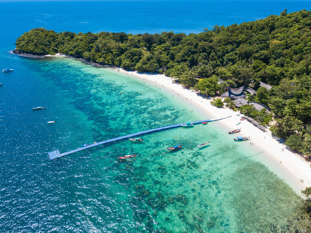 น้ำทะเลสีฟ้าใสและแนวปะการังที่หาดกล้วย เกาะเฮ ภูเก็ต พักผ่อนเมื่อไปเที่ยวคนเดียว